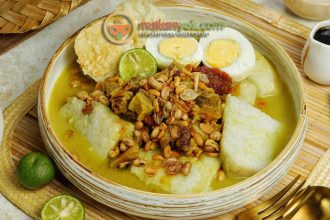 Porsi hangat Lontong Kari ayam dengan kuah kuning kental dan taburan emping di pasar tradisional Bandung