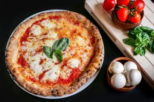 Pizza Margherita autentik sebagai makanan khas Italia dengan topping keju dan saus tomat segar